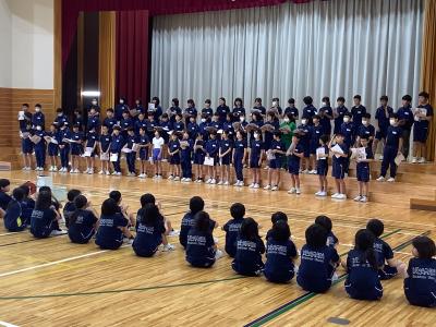 合唱する６年生とそれを見る２年生