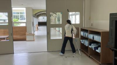 さすまたを持ち防犯扉を閉める教員