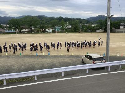 行進のために校庭外周に整列する鼓笛隊