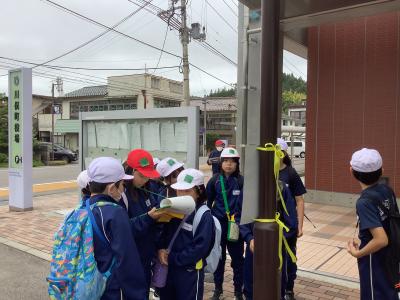 チェックポイントの役場でクイズを考える児童